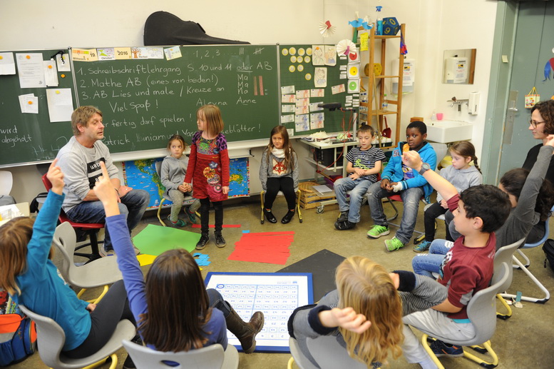 Schüler und Lehrer im Sitzkreis